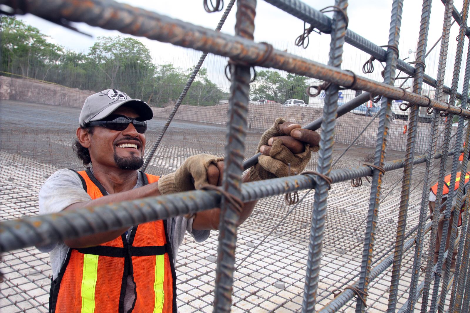 Steel fixer securing reinforcement bar on a construction site